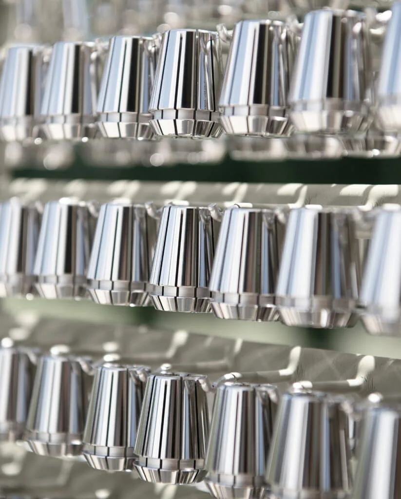 Mehrere Reihen von glänzenden Spannzangen, sorgfältig auf einem Gestell präsentiert.