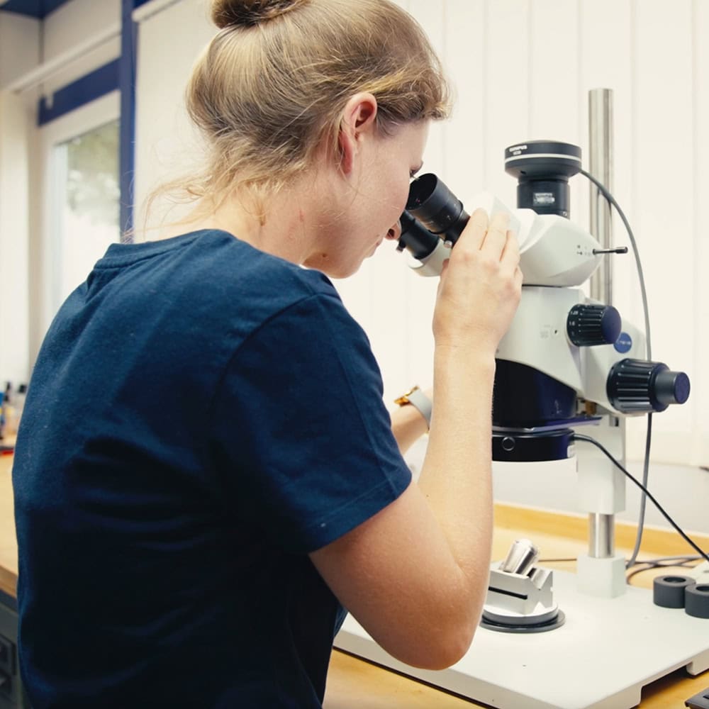 FAHRION company – guiding principles with an employee at the microscope