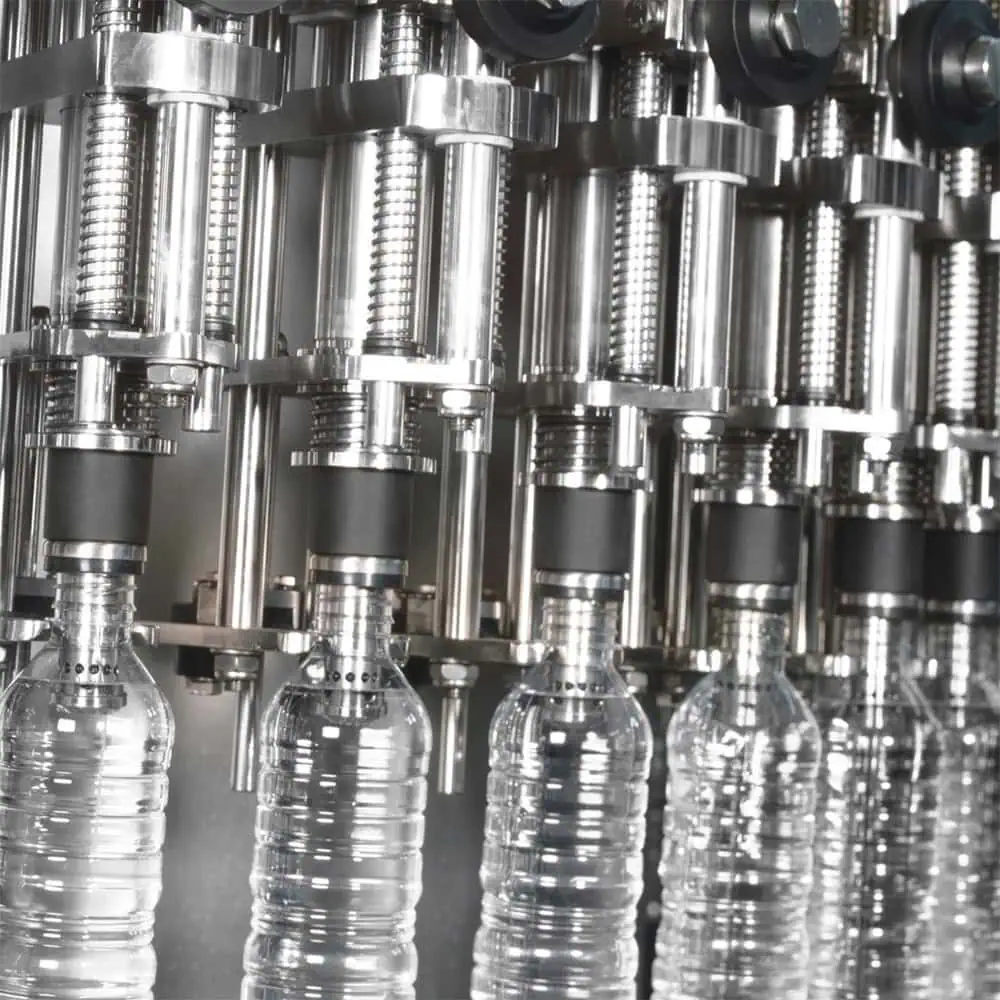 Automatic filling machine that fills several plastic bottles at the same time.