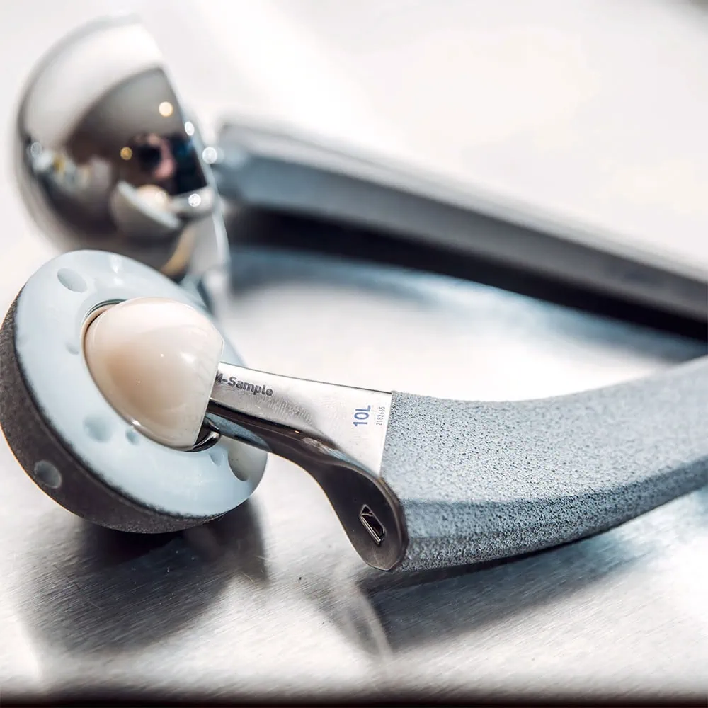 Metal hip joint prosthesis lying on a smooth surface.