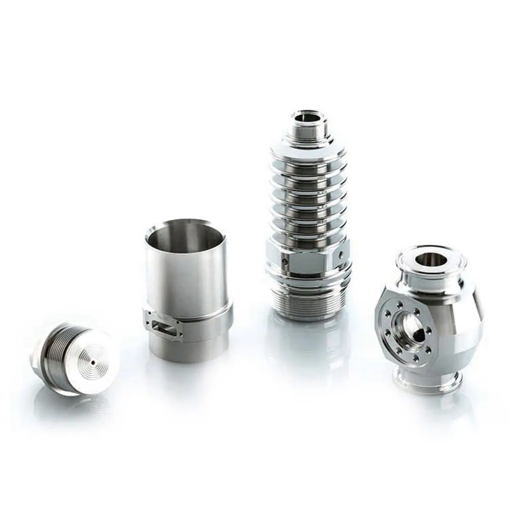 Four precision metal components of different shapes on a white surface.